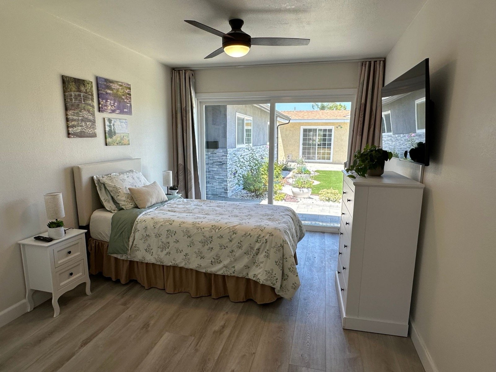 Semi-private bedroom with floral bedding and a sliding door to the garden
